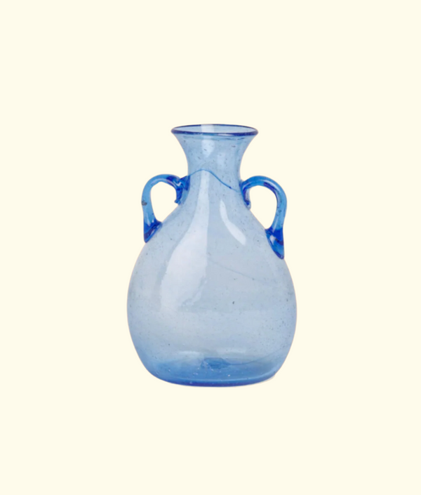 Blue glass vase with two handles on a beige background