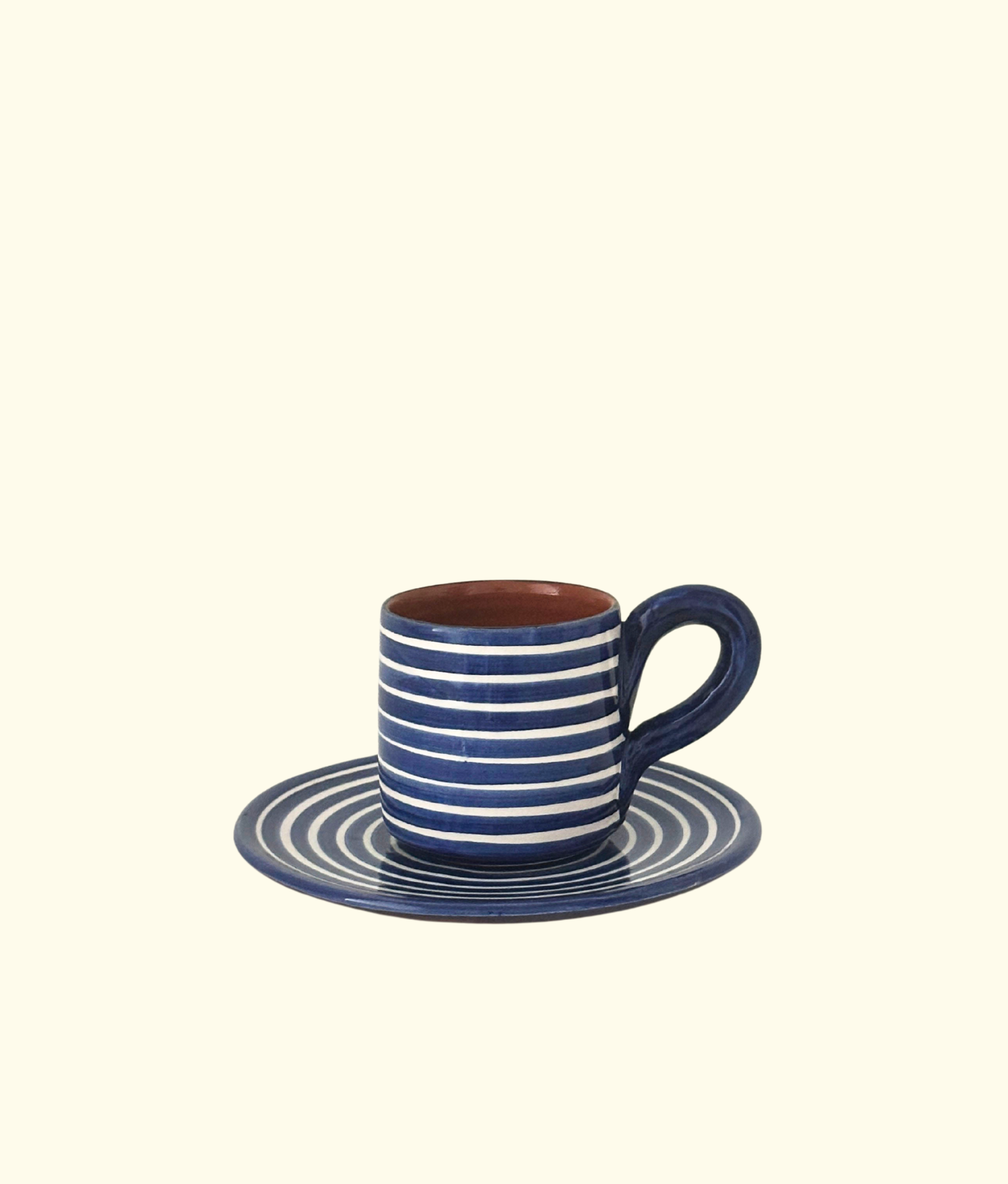 Blue and white striped ceramic cup and saucer on a beige background